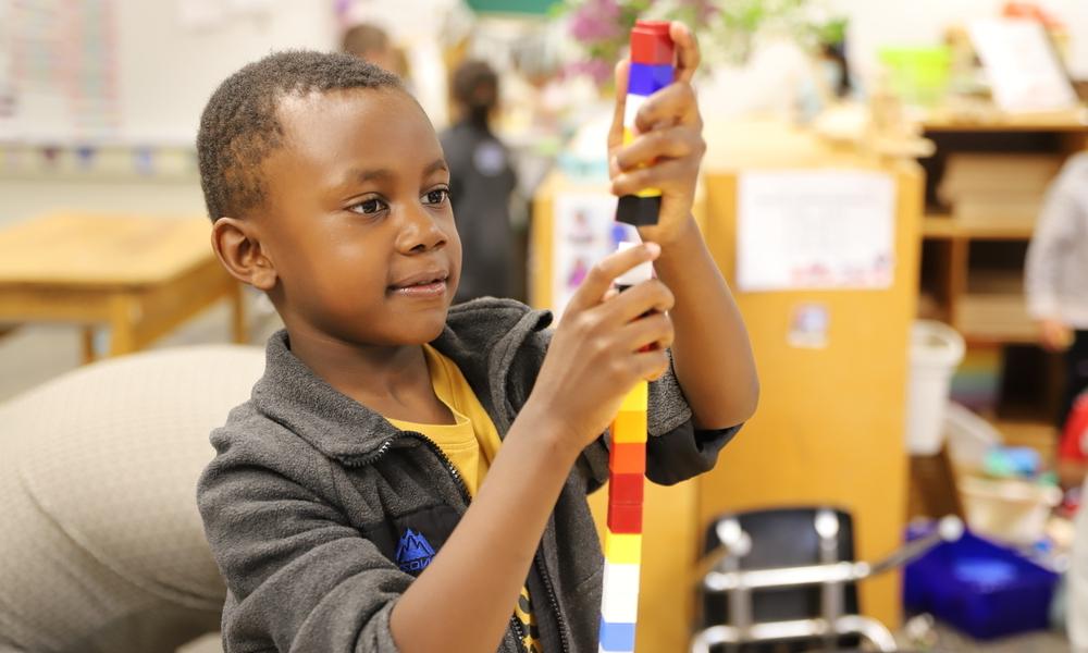 Young child stacking Lego blocks